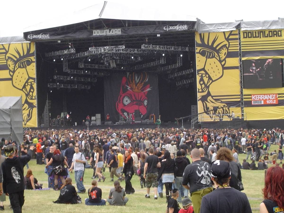 A large festival stage at Donington Park seen across a field of people