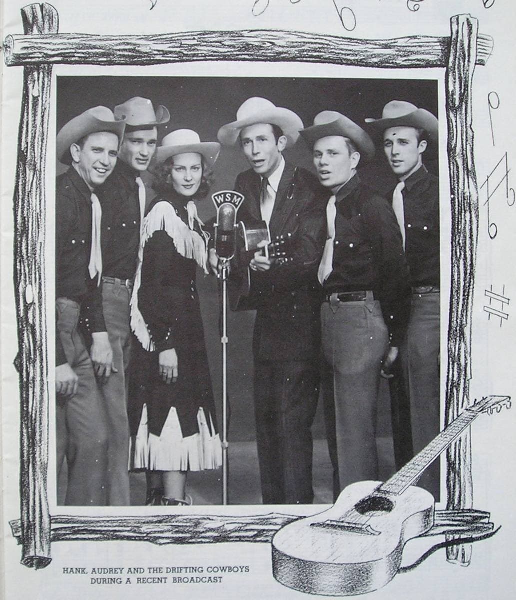 Hank Williams singing at a WSM microphone with Audrey Williams in a fringed outfit and four band members in hats