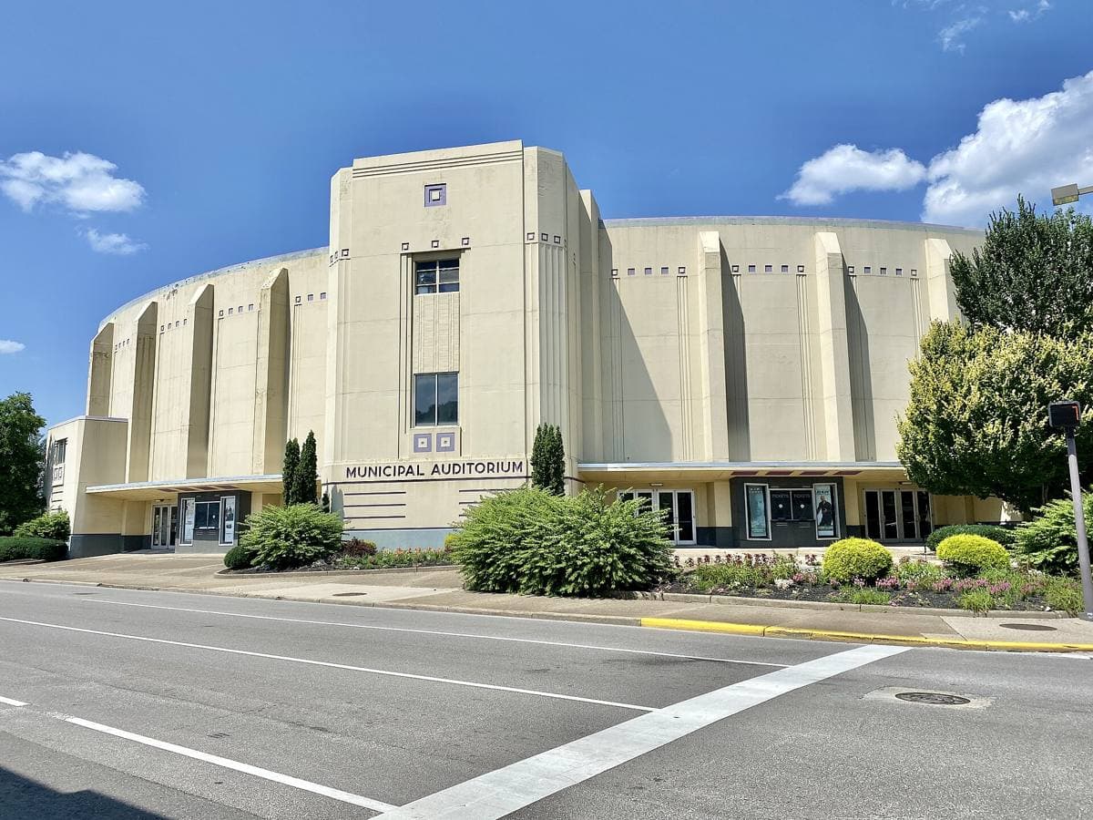 A cream Art Moderne auditorium with a curved corner and tall windows