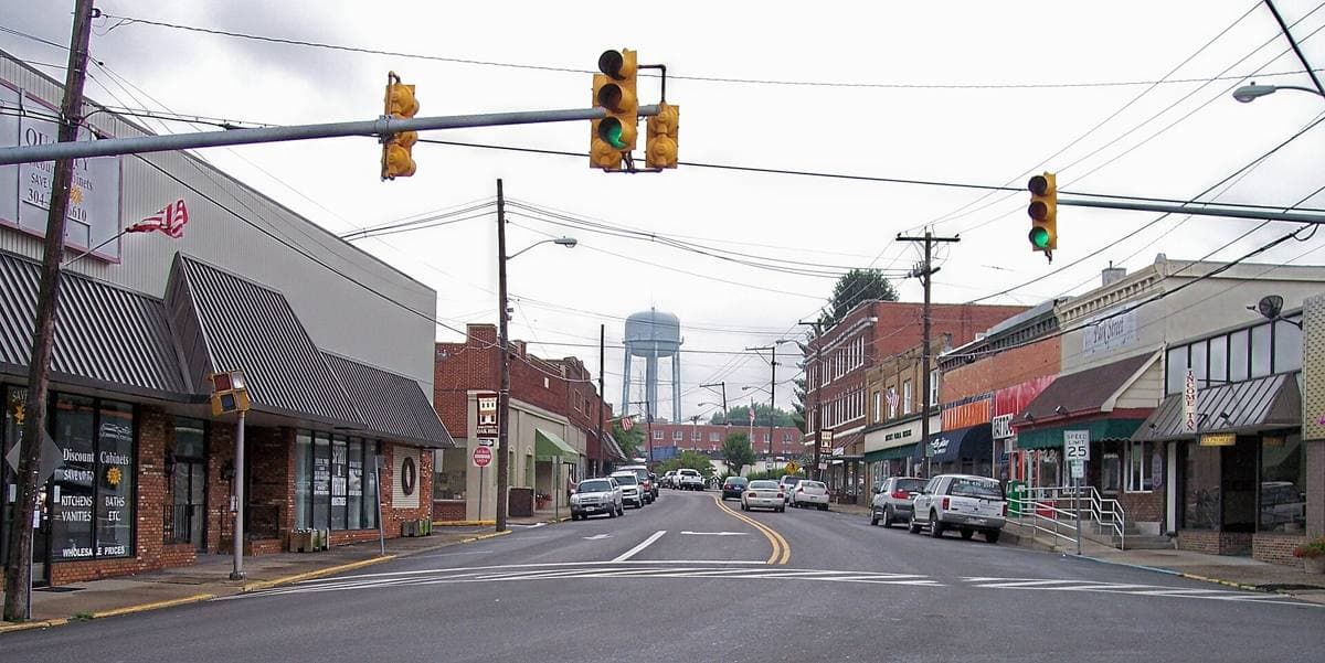 A small-town main street with low brick shops under a summer sky