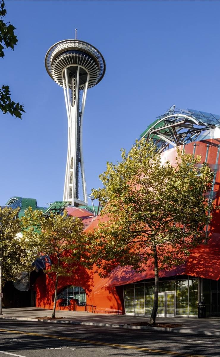 The curving metal Experience Music Project building with the Space Needle behind it
