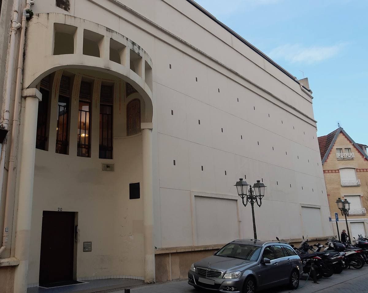 A tall cream former cinema with a curved entrance