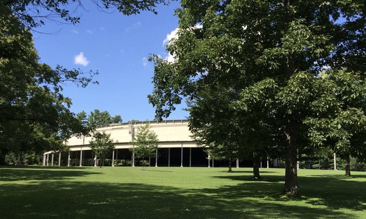 A wide open-sided concert shed with a lawn in front of it
