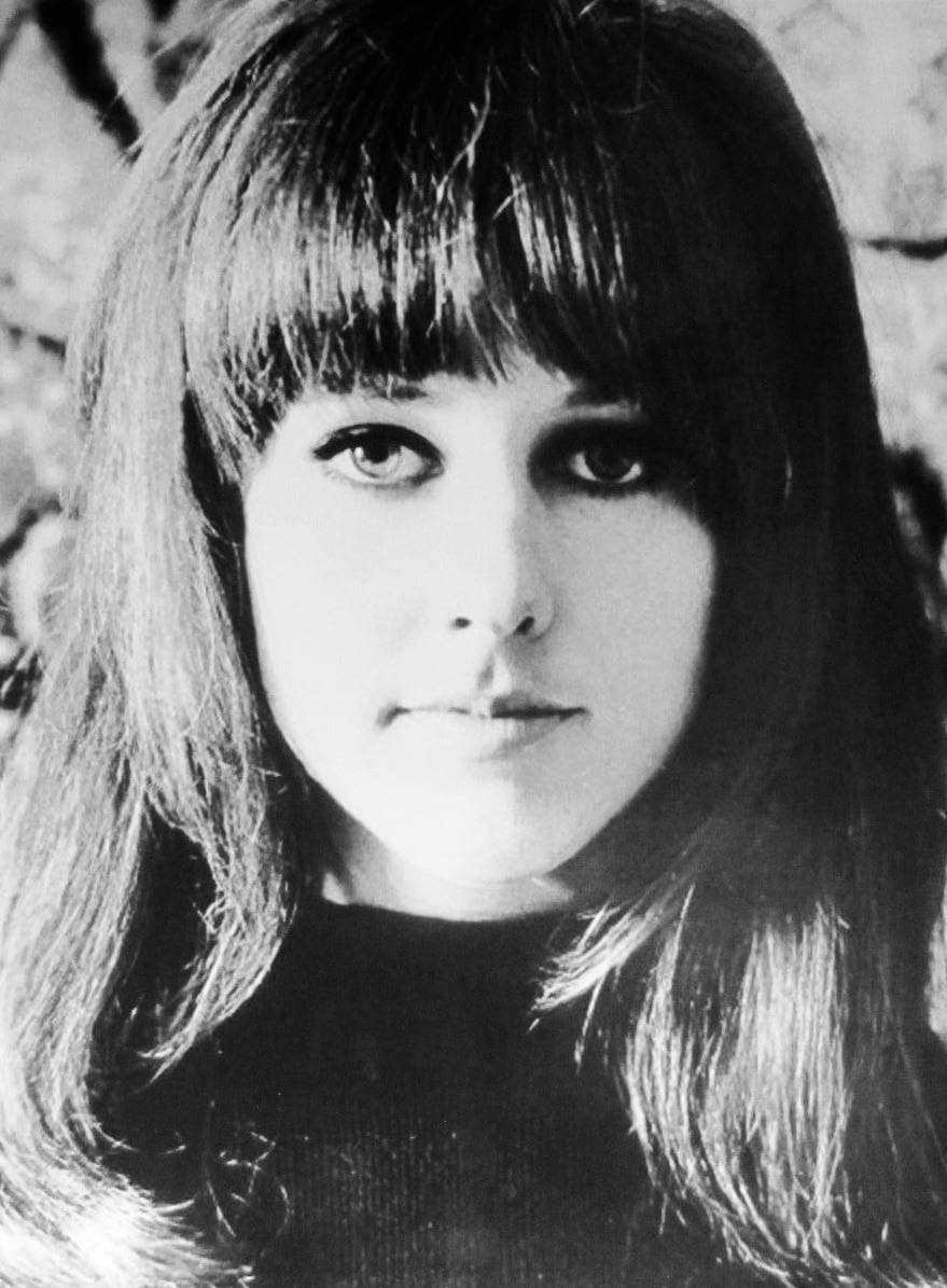 Grace Slick in black and white, long dark hair and fringe, looking straight at the camera
