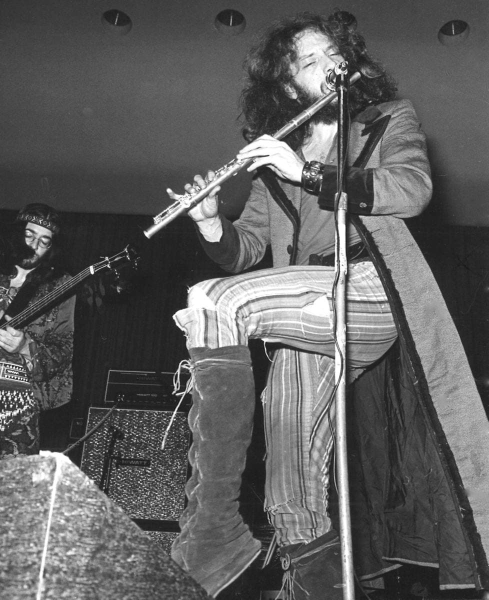Ian Anderson playing the flute on stage in 1970, long hair and beard, a bass player beside him