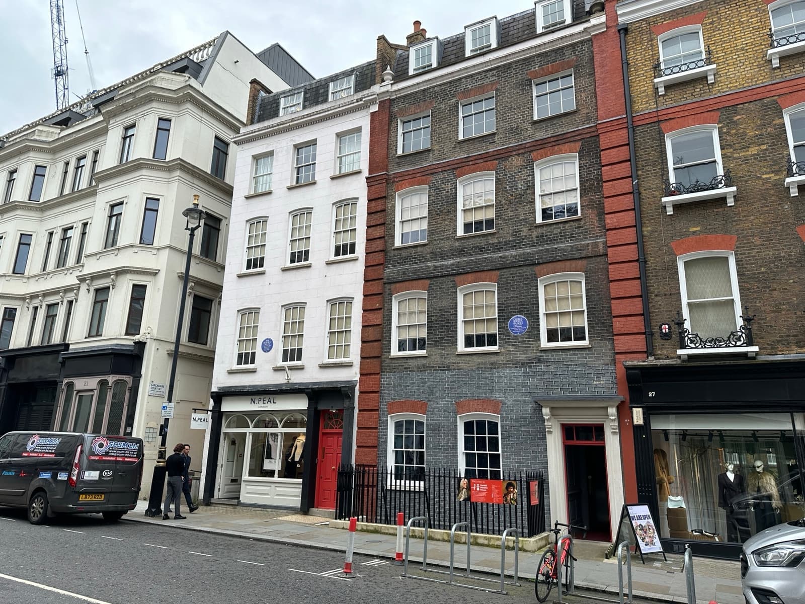 Two Georgian brick townhouses on Brook Street with blue plaques