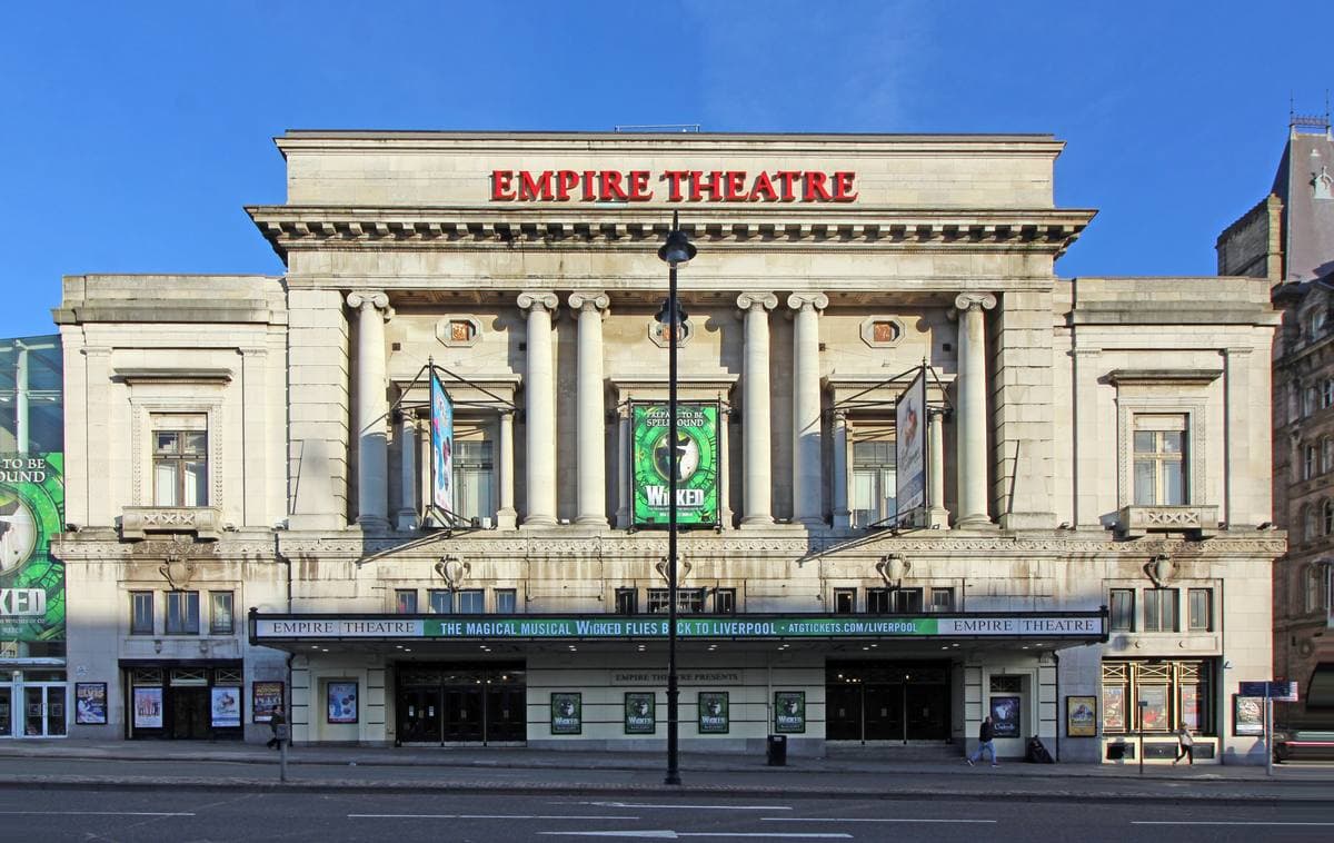 A grand pale stone theatre front with columns and EMPIRE THEATRE in red letters along the top