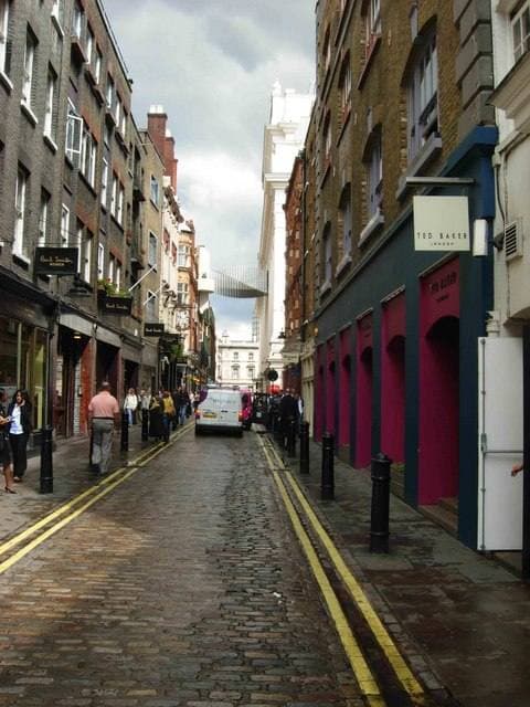 A narrow cobbled street between brick buildings and shopfronts in Covent Garden