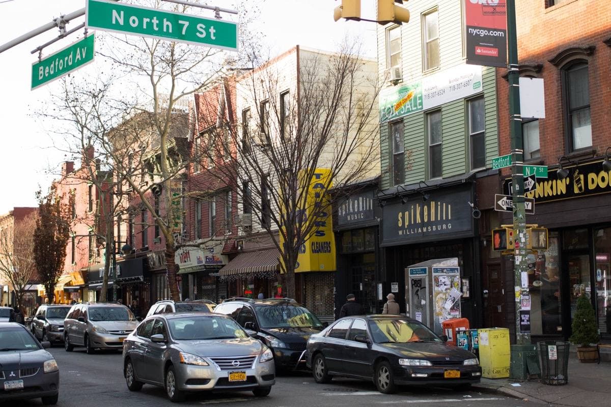 A Brooklyn street corner with shops and low brick buildings