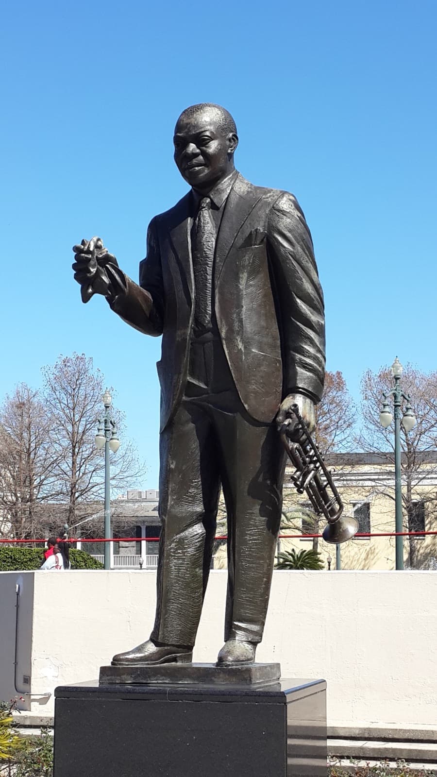 A bronze statue of Louis Armstrong holding his trumpet and handkerchief