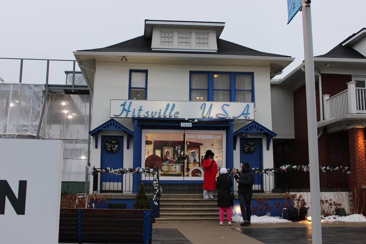 The white two-storey Hitsville U.S.A. house with its blue sign, visitors on the steps and construction hoardings beside it