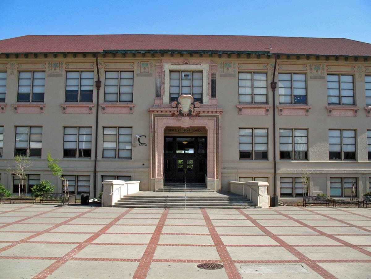 A white classical school building with tall columns on the Berkeley High campus