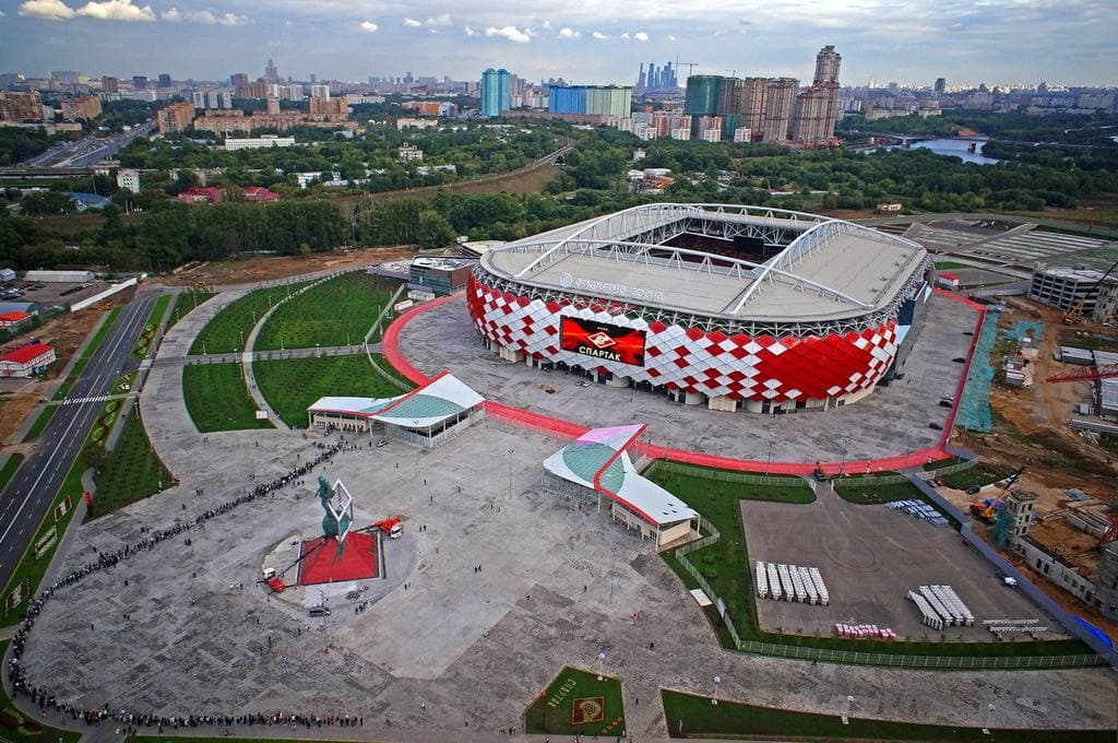 A red-and-white football stadium at dusk