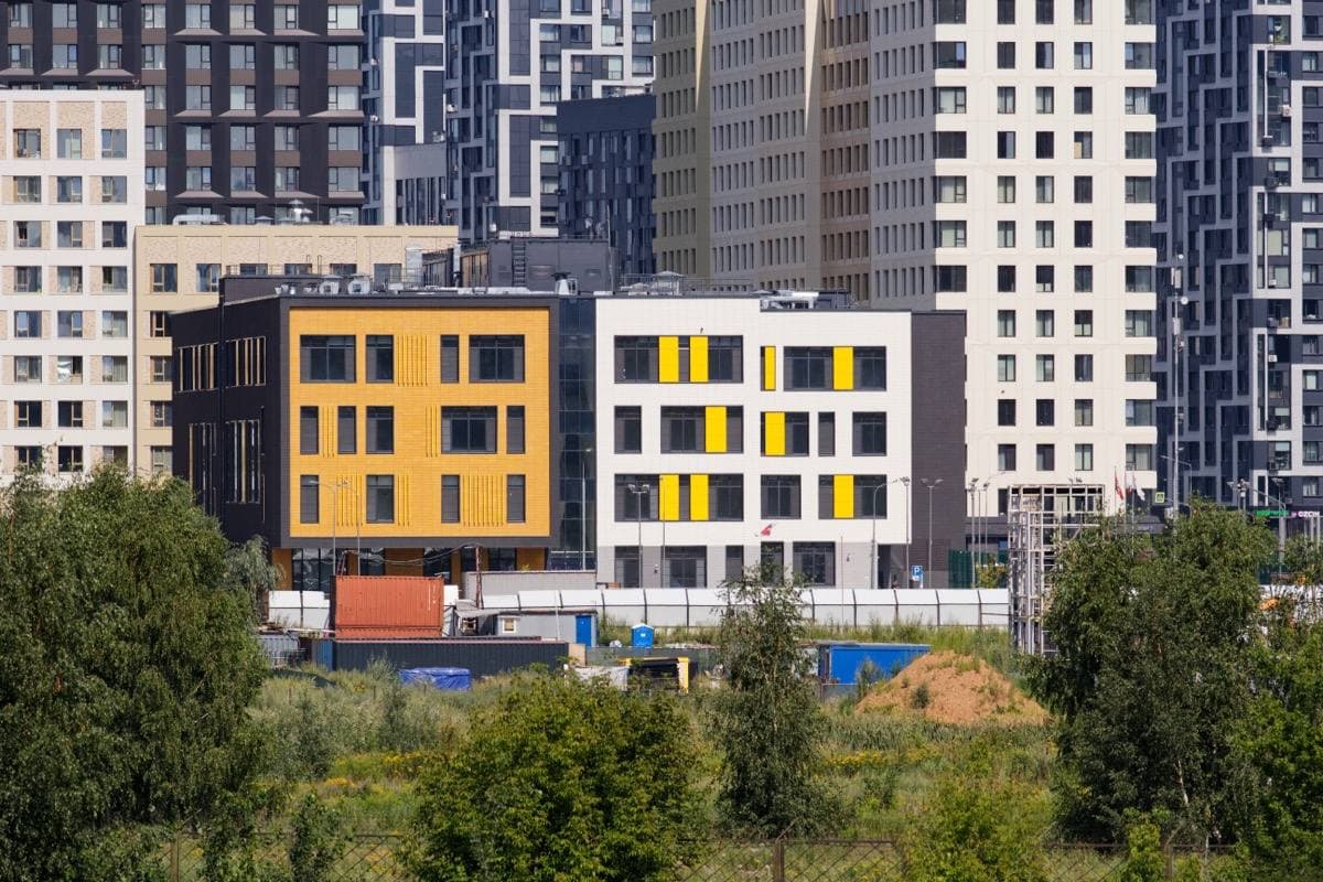 Tall new apartment blocks across a river on a summer day