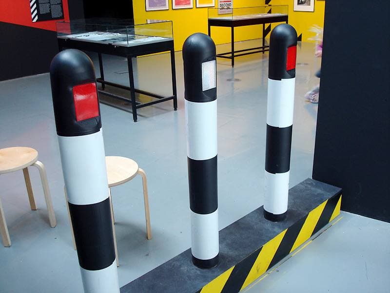 Three black-and-white striped bollards with red reflectors