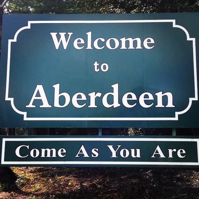 A green and white sign reading Welcome to Aberdeen, with Come As You Are on a board beneath