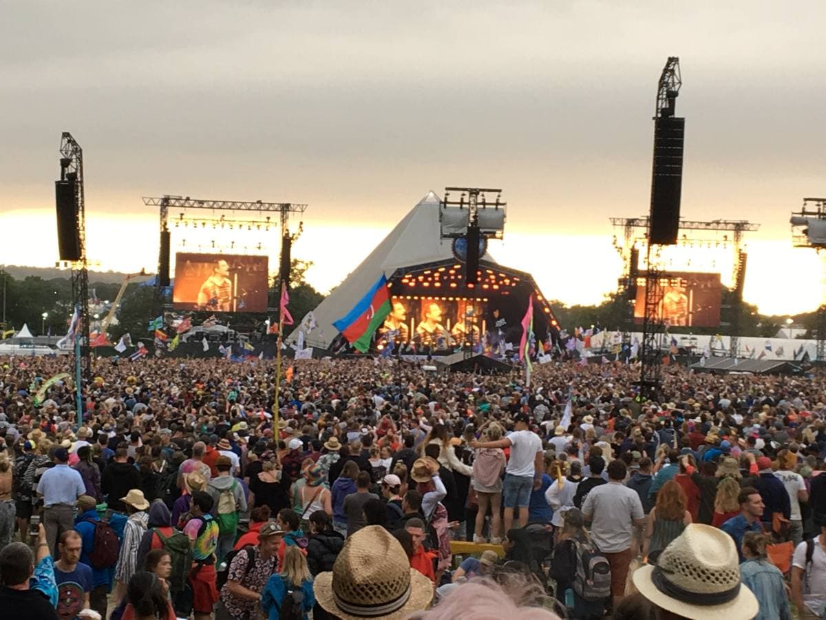 The Pyramid Stage at Glastonbury seen across a large crowd