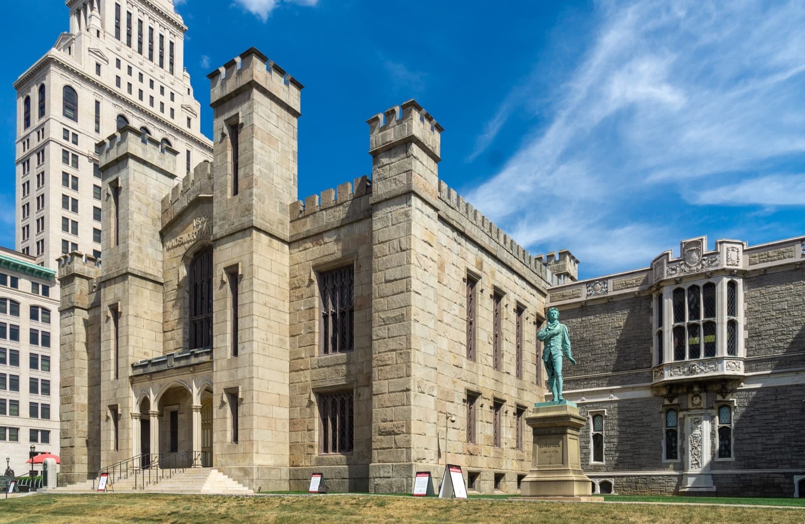 A pale stone museum built like a small castle with turrets, under a blue sky