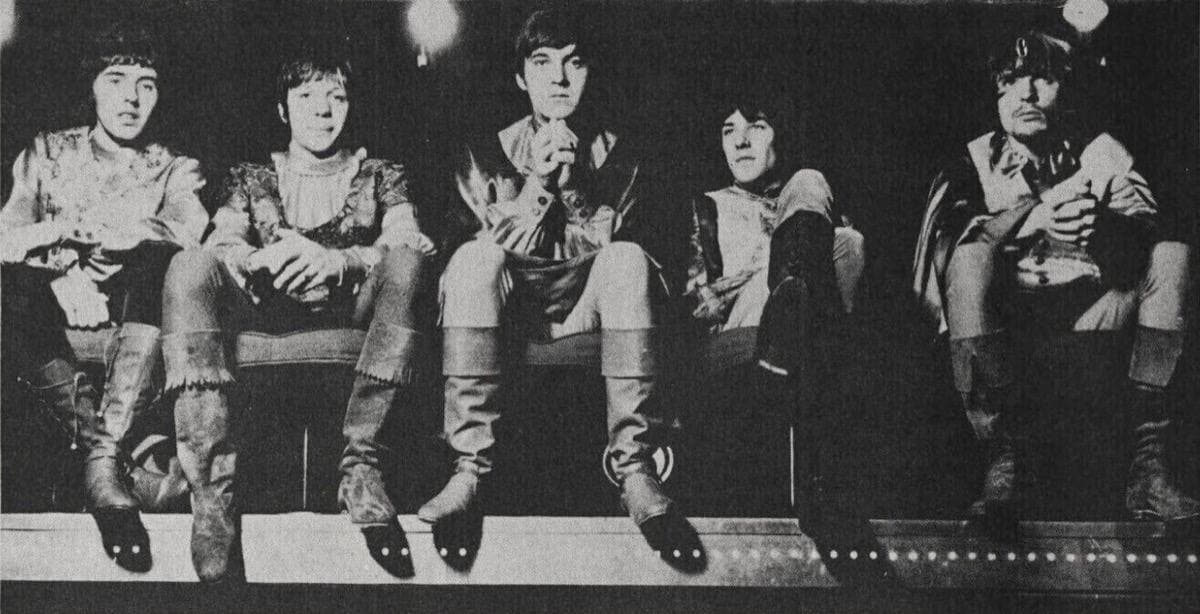 The band posed in a wide black-and-white group photograph