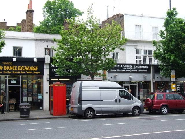 Music & Video Exchange on Notting Hill Gate in 2009: a row of shops with a red phone box and a white van at the kerb