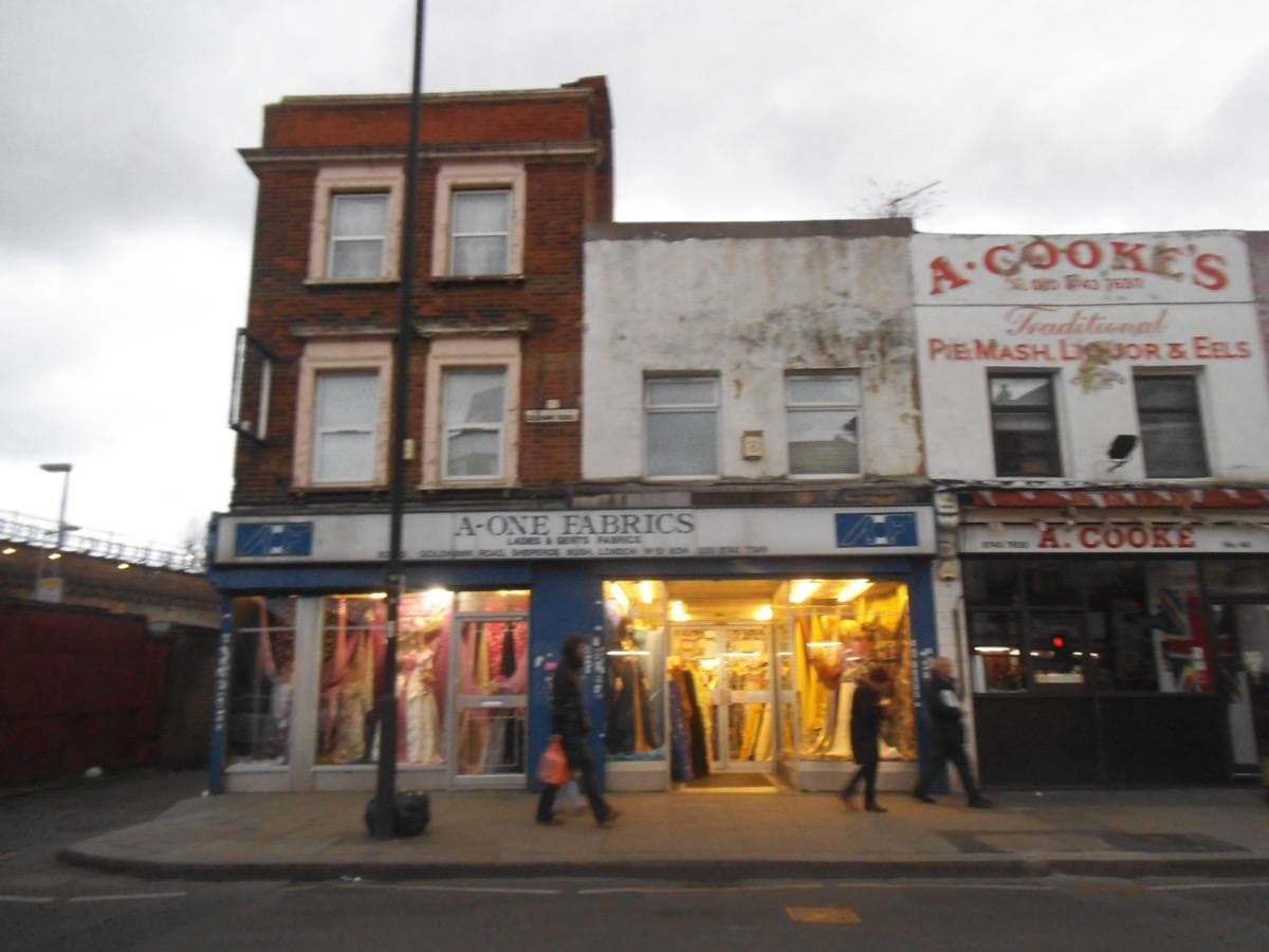 Shops on Goldhawk Road, Shepherd’s Bush, at dusk, one shop front lit