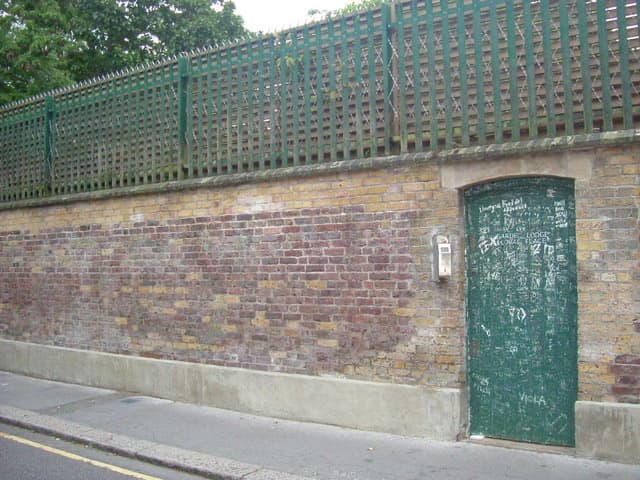 A high brick wall with messages from fans