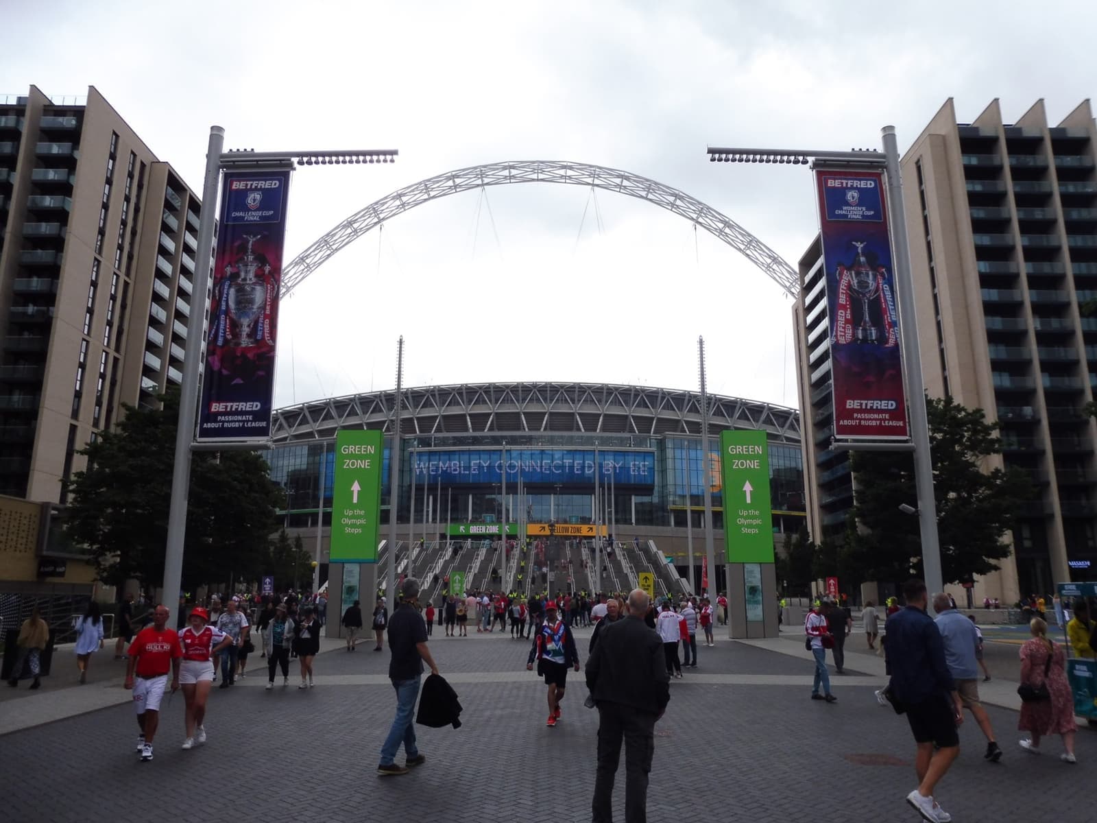 Crowds walking up Olympic Way towards Wembley Stadium and its arch