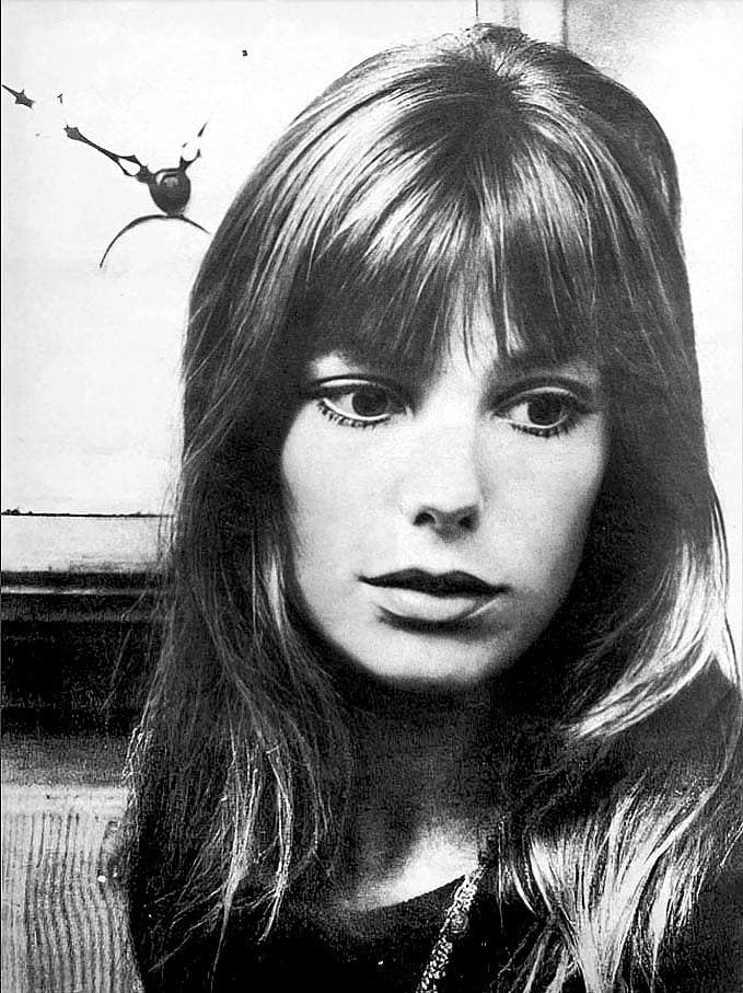 Jane Birkin in black and white, long hair with a fringe, looking past the camera