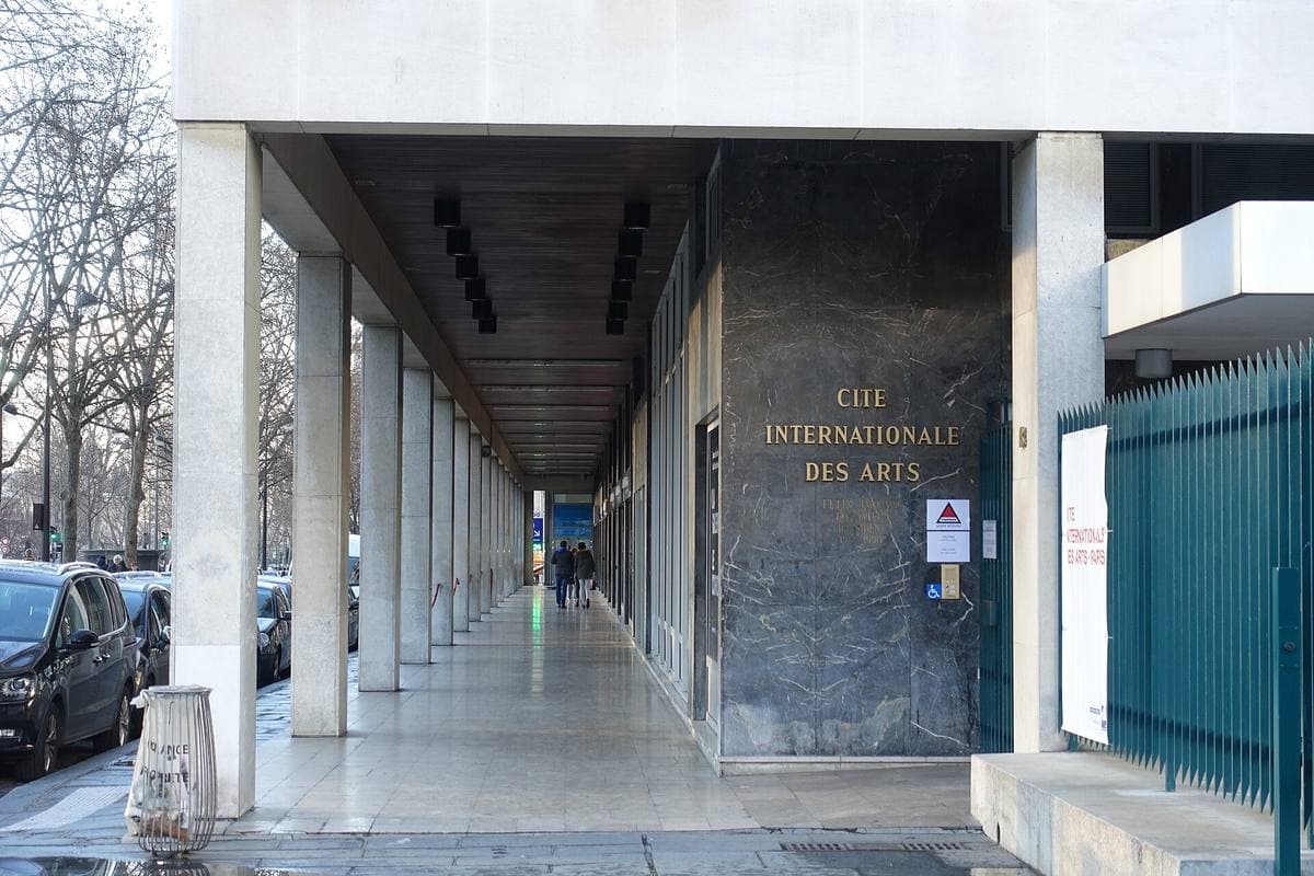 A long modern colonnade with the Cité internationale des arts name on a dark panel