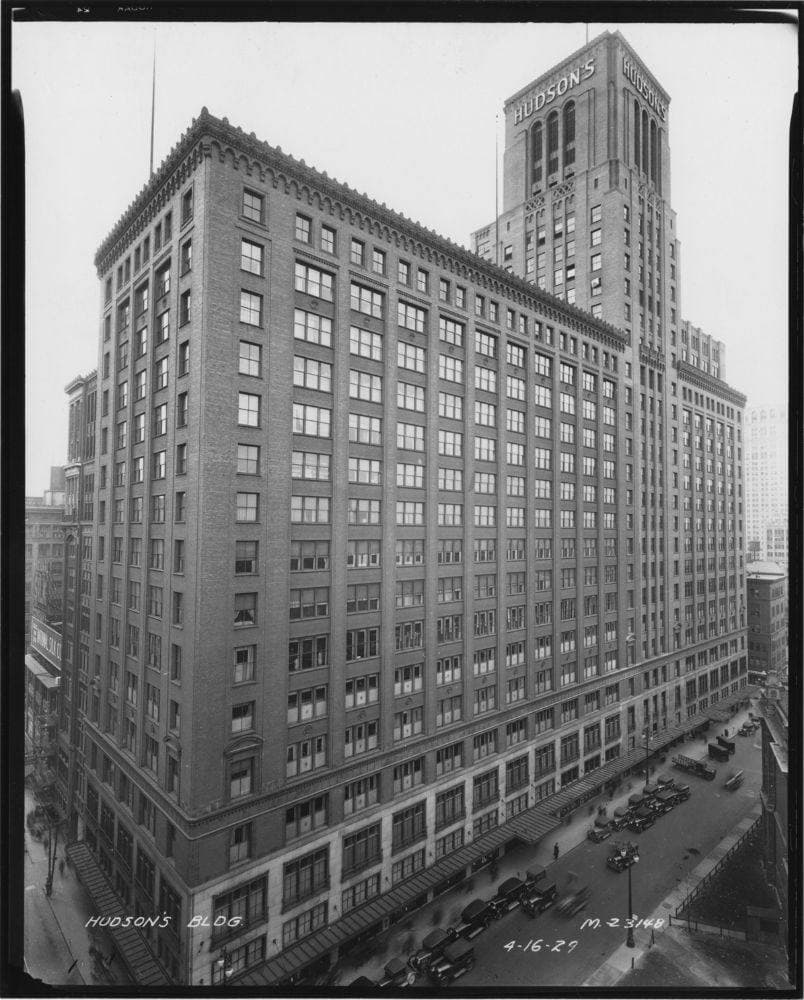 A tall brick department store filling a city block, with streetcars below