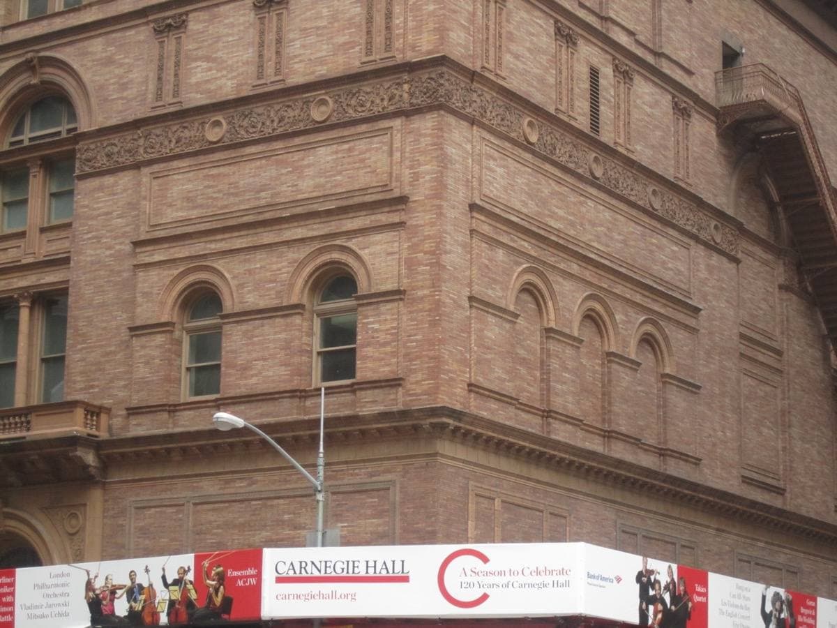 The brick and stone front of Carnegie Hall with arched windows