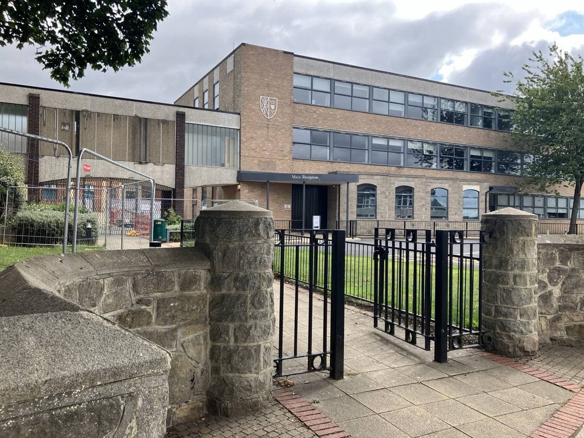A modern school building behind railings