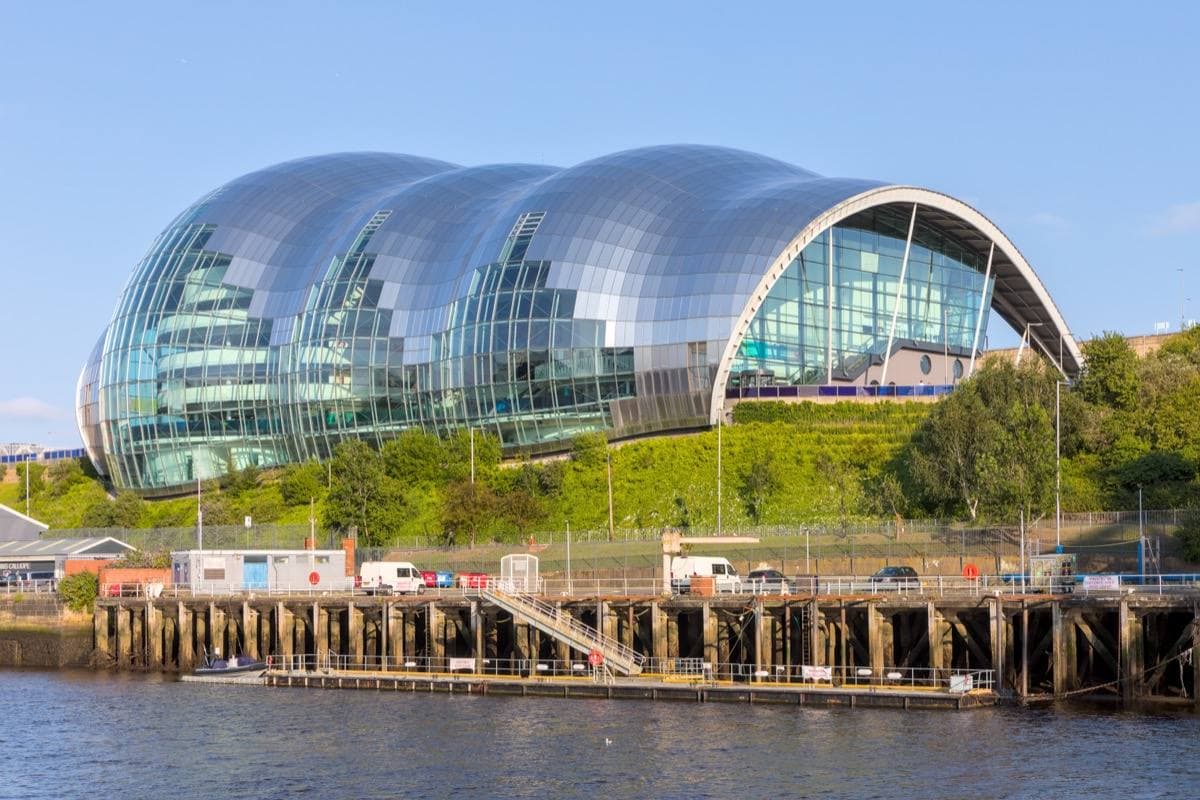 A curved glass and steel concert hall beside the River Tyne