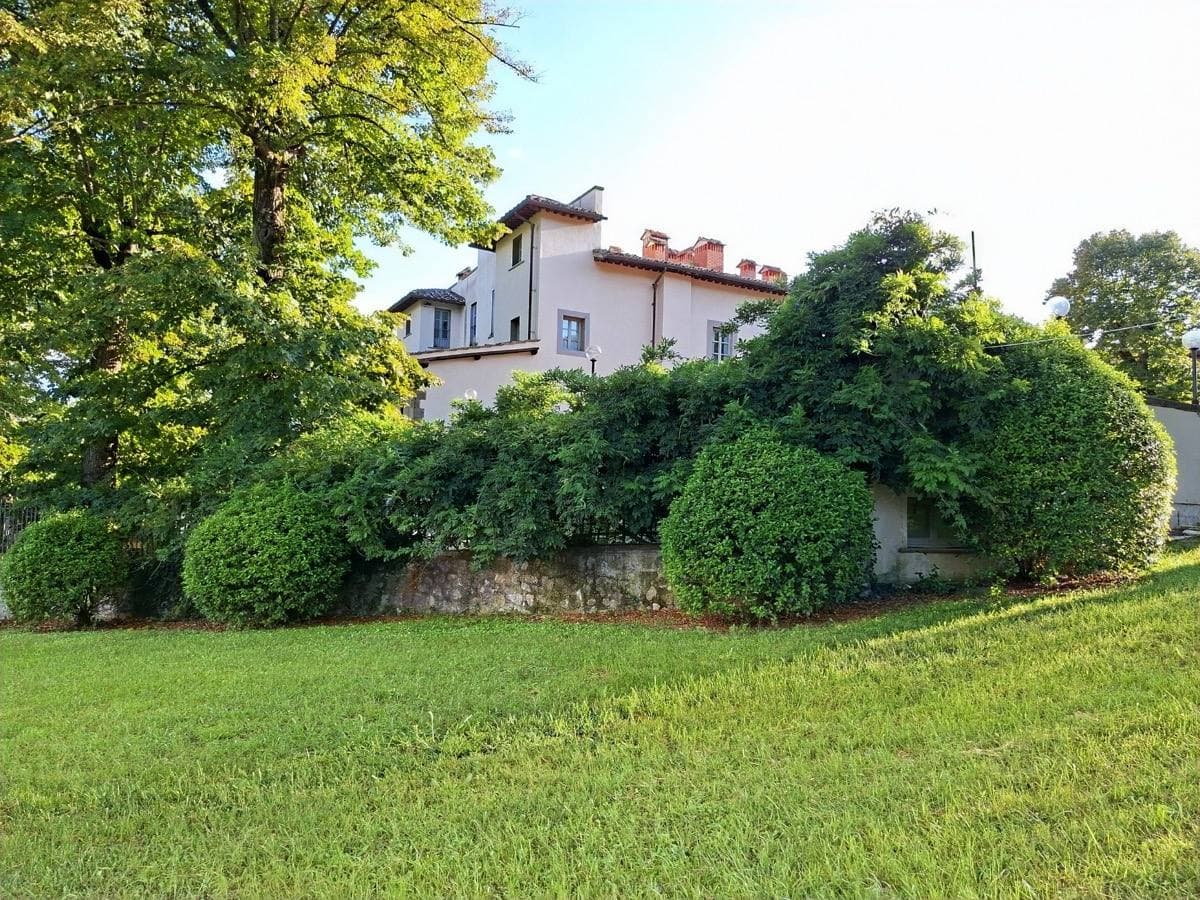 A long Tuscan villa with terracotta roofs among trees