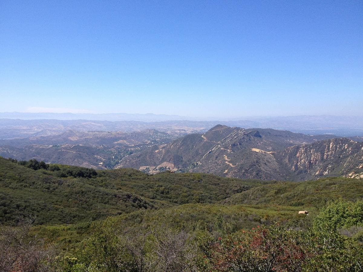 A winding canyon road between green hills