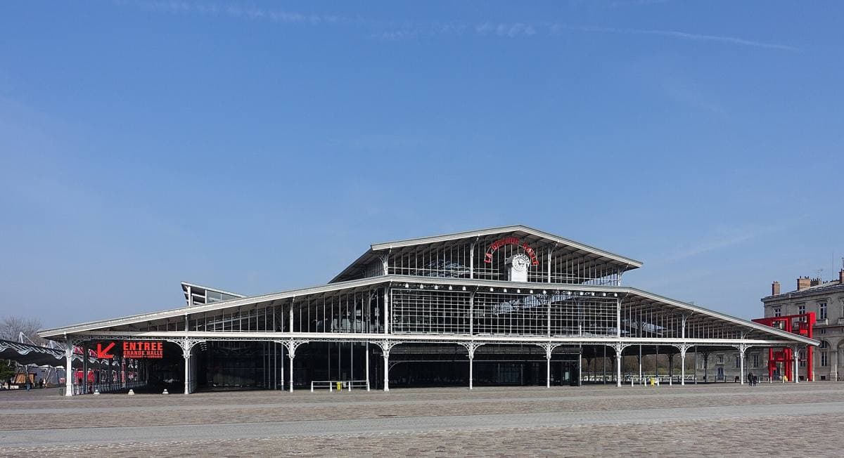 A long iron-and-glass market hall in a Paris park