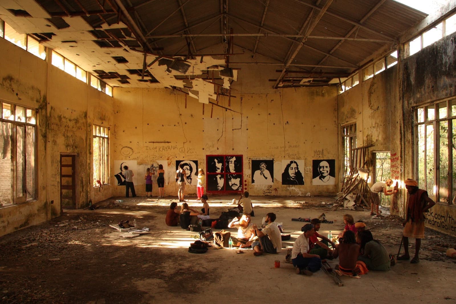 A roofless hall with murals on its walls