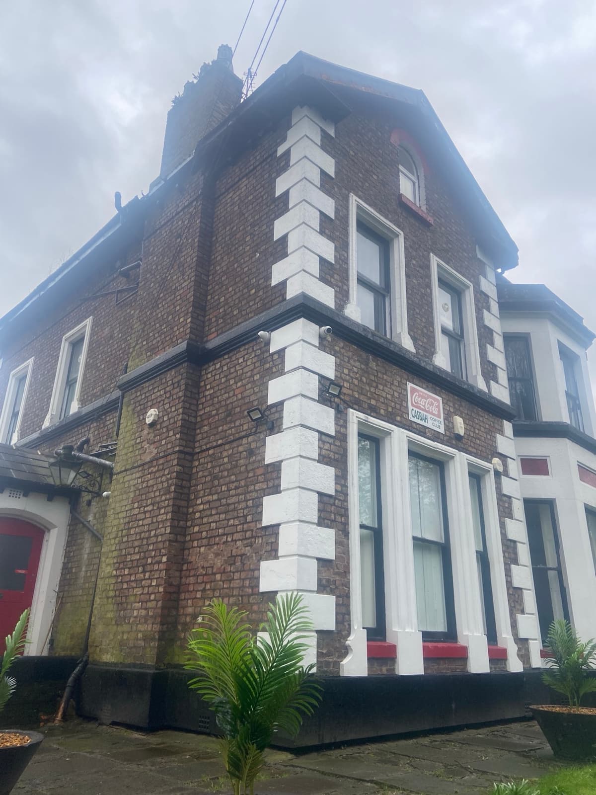 A large Victorian house with a sign for the club