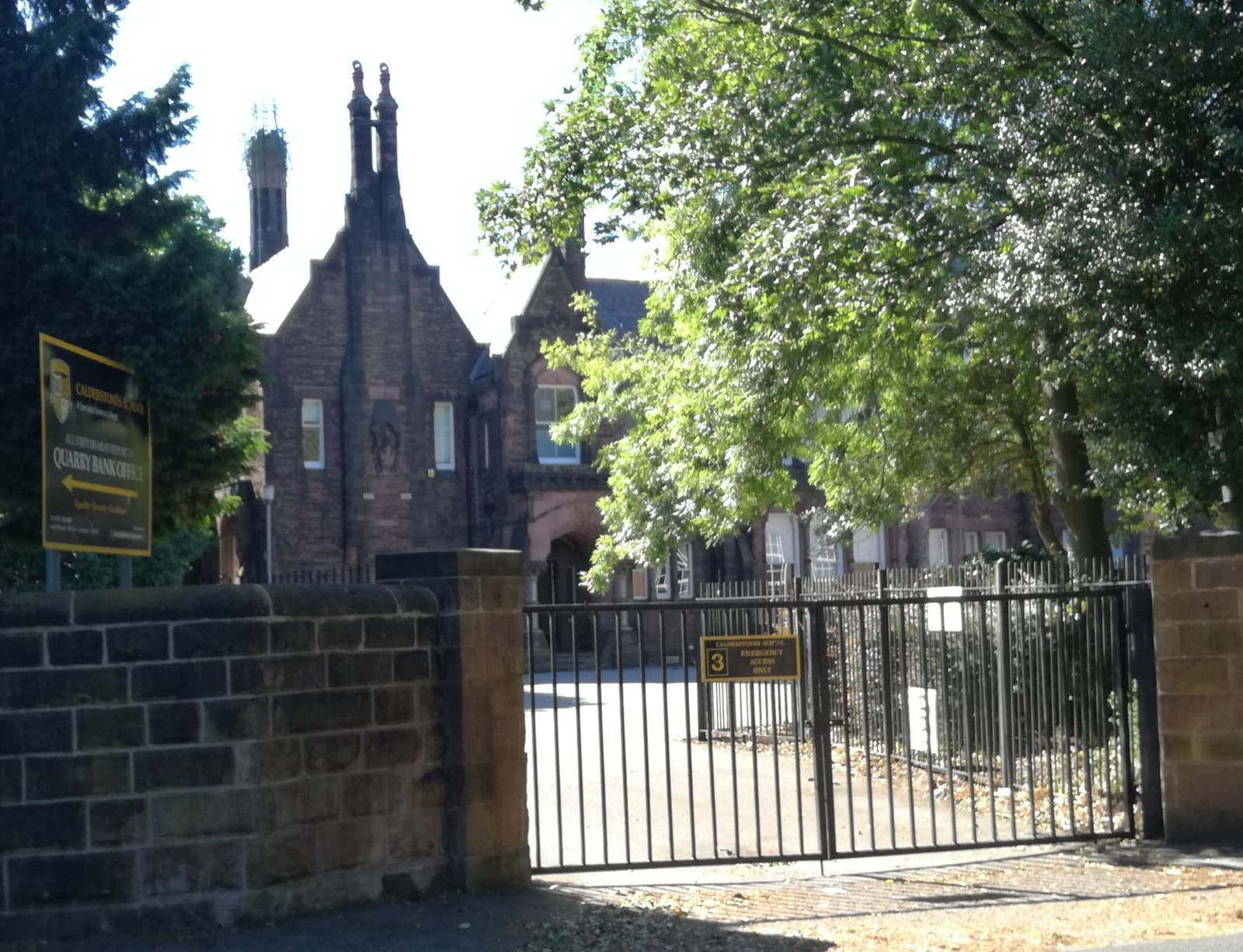 A sandstone school building with tall chimneys