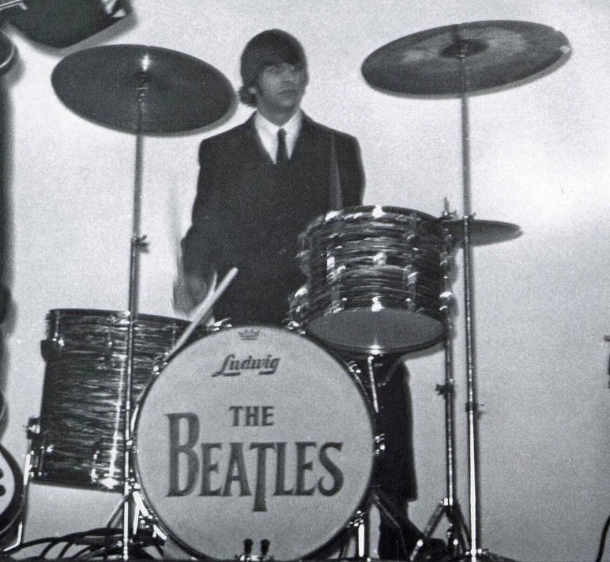 Ringo Starr in a dark suit behind his drum kit