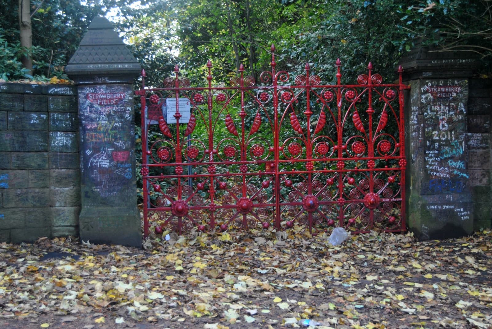 Red iron gates between sandstone pillars