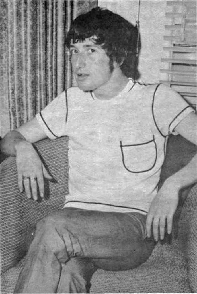 Pete Quaife in a pale T-shirt sitting in an armchair, black and white