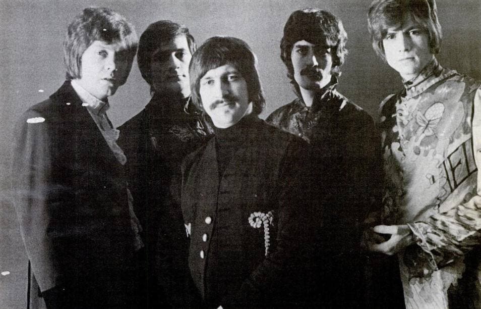 Five young men in late-1960s clothes posed together in a black-and-white publicity photograph