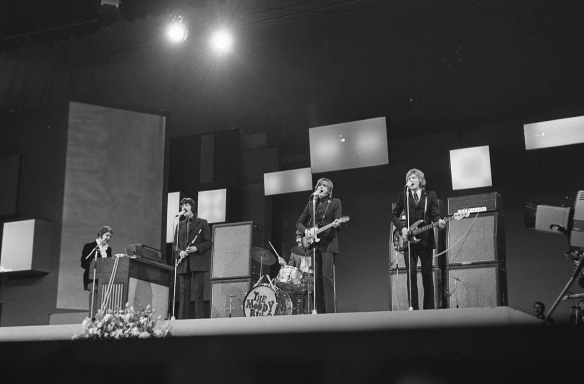 The band playing on a lit stage in 1969, in black and white