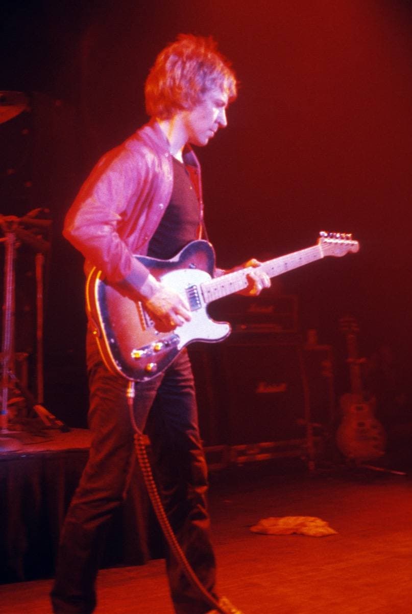 Andy Summers playing a guitar, lit red