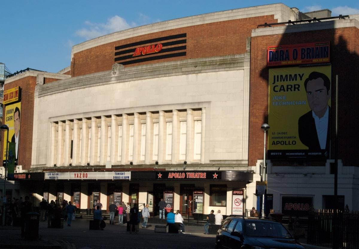 A broad pale art deco cinema front with a long canopy on a London street