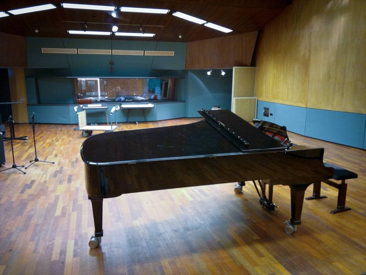 A large wood-panelled recording room with daylight from high windows
