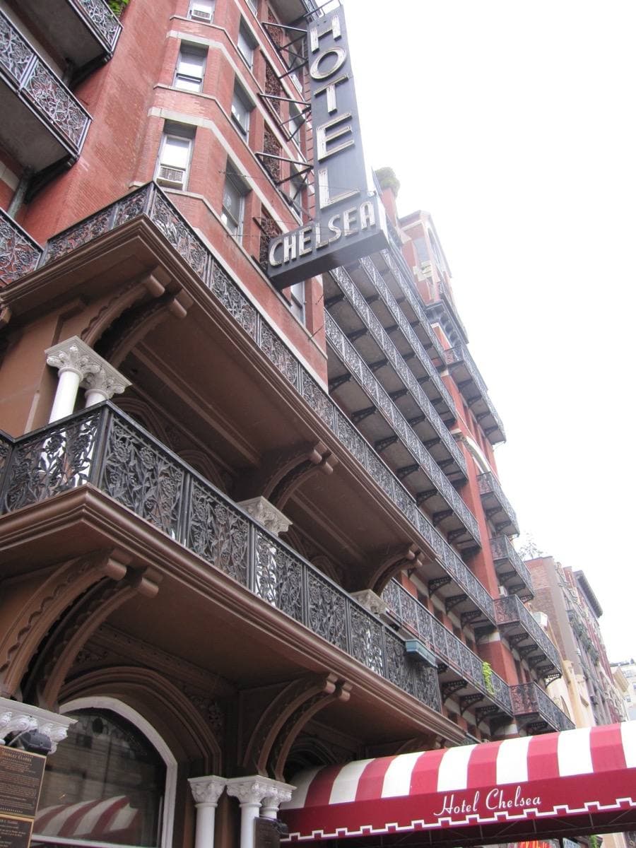 A tall red-brick hotel front with iron balconies