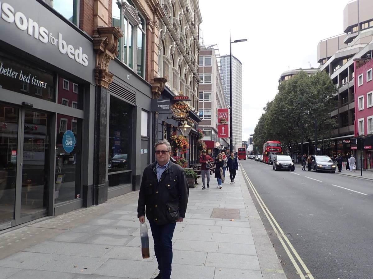 A busy London shopping street with buses