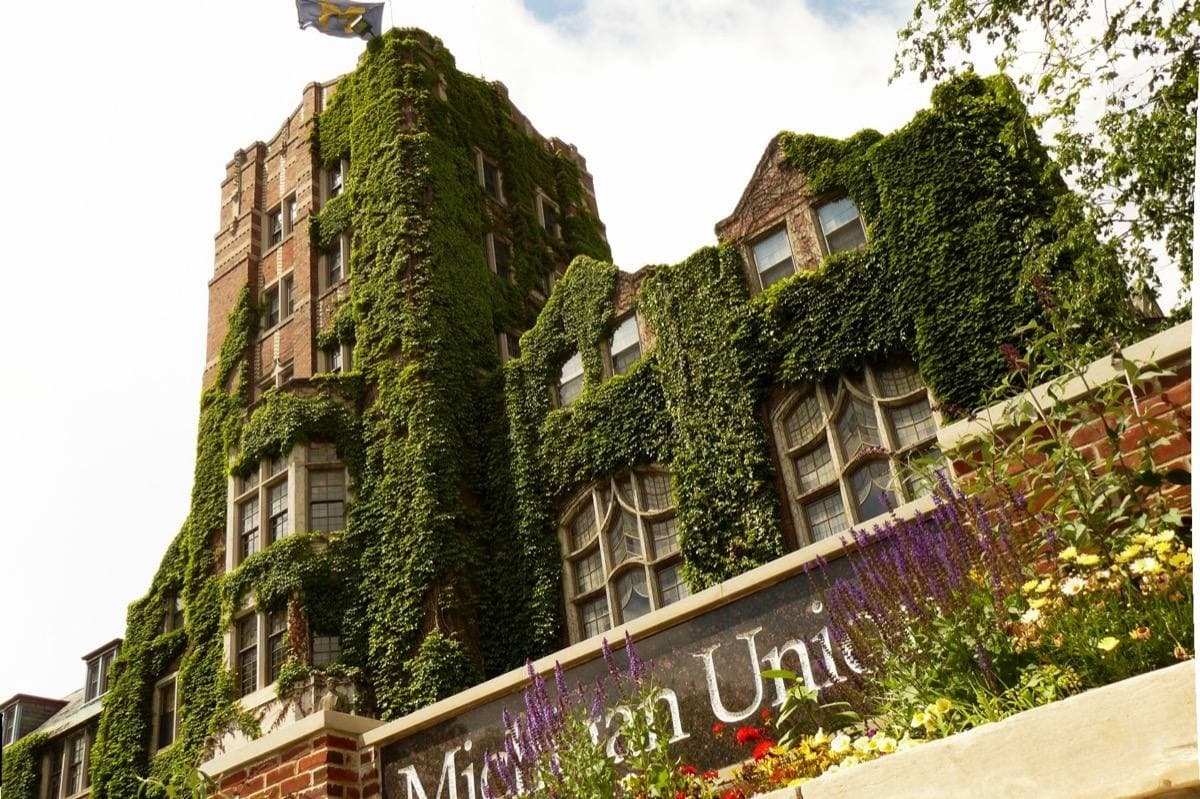 A large brick and stone university building with a central tower